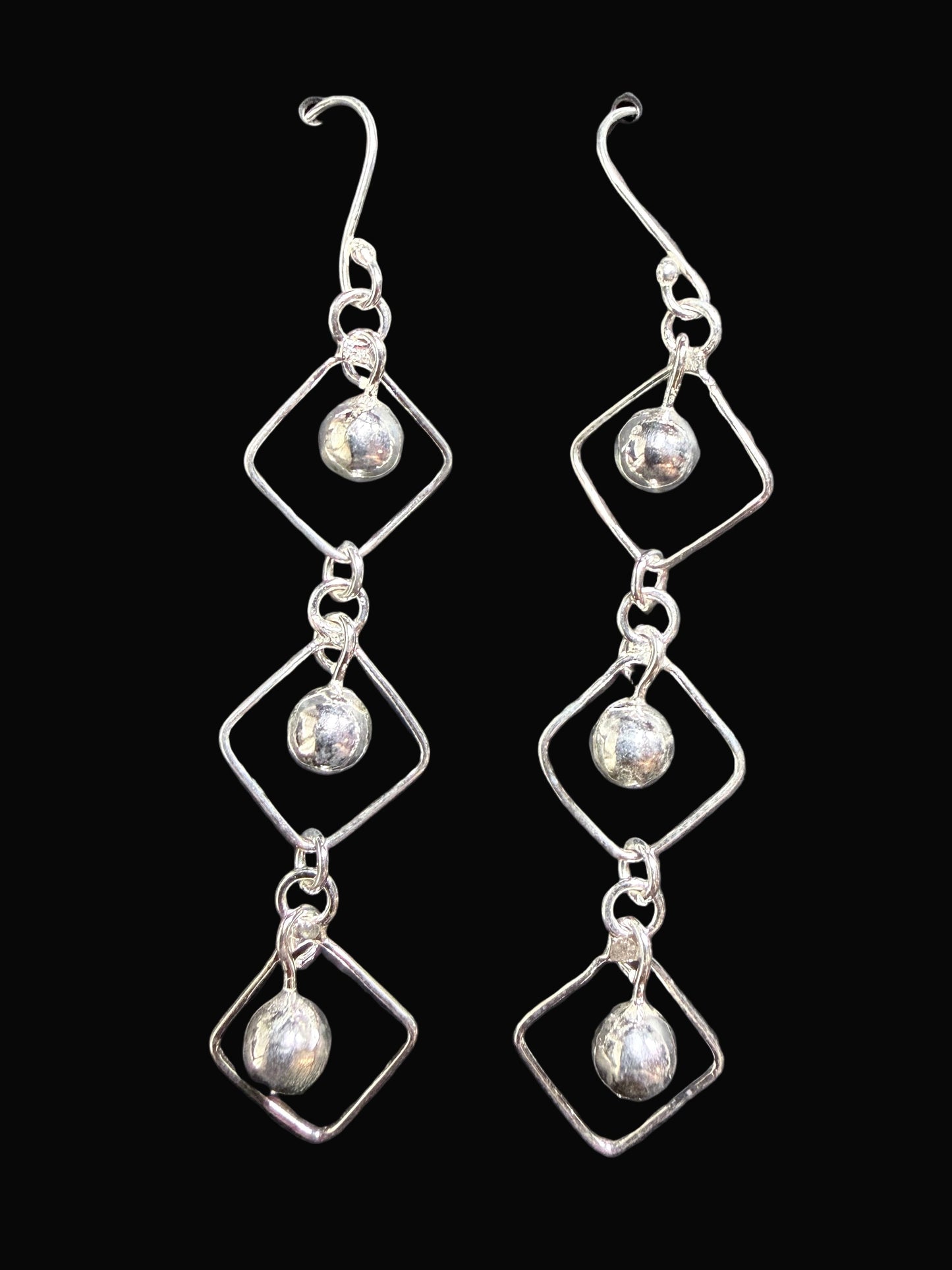 Pair of silver earrings on a gray card