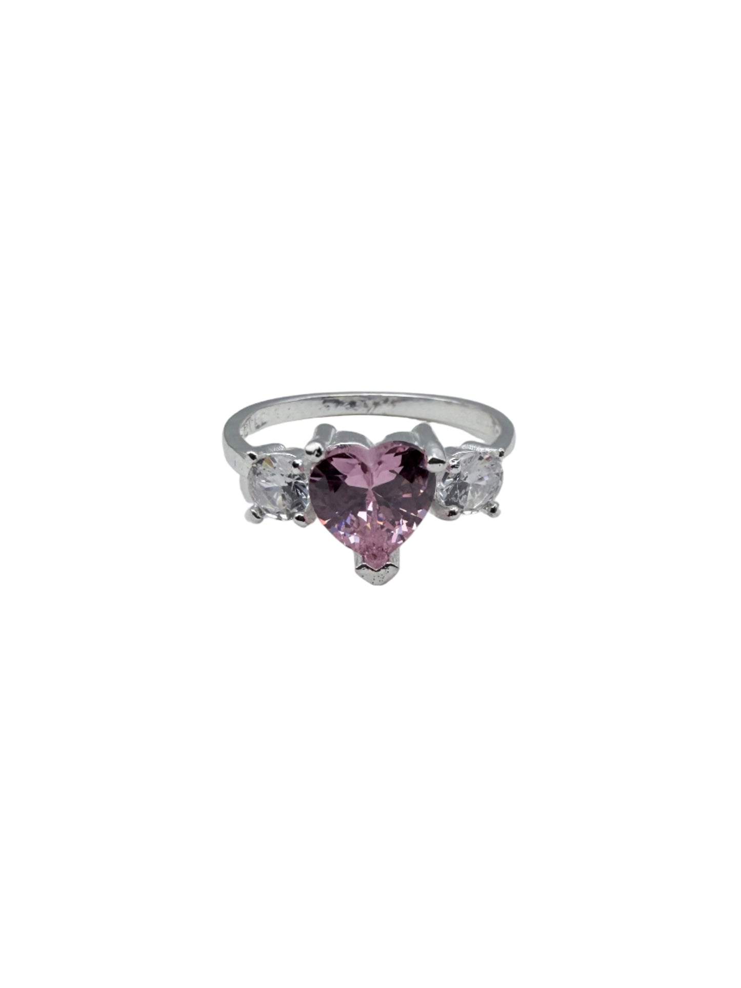 Silver ring with pink gemstone on a white stand against a gray background