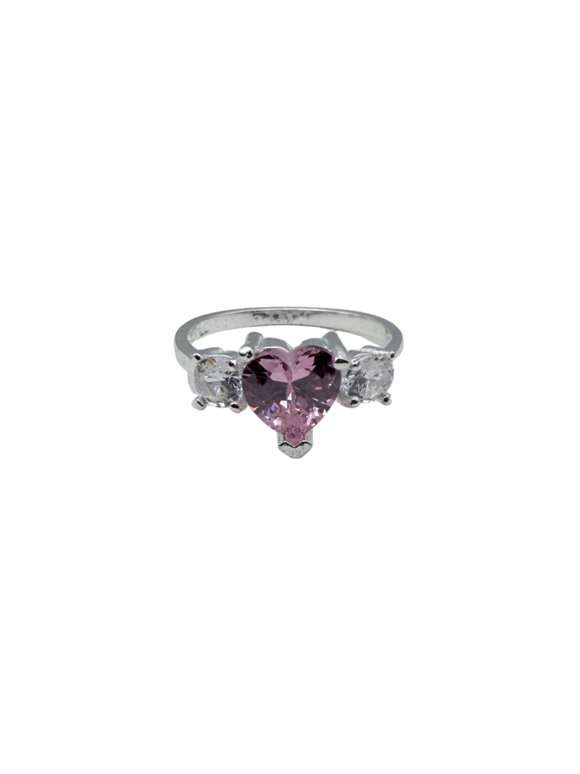 Silver ring with pink gemstone on a white stand against a gray background
