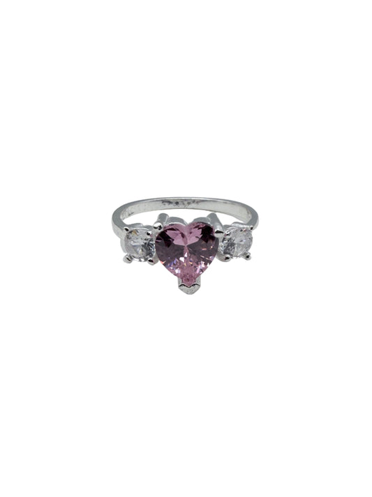 Silver ring with pink gemstone on a white stand against a gray background