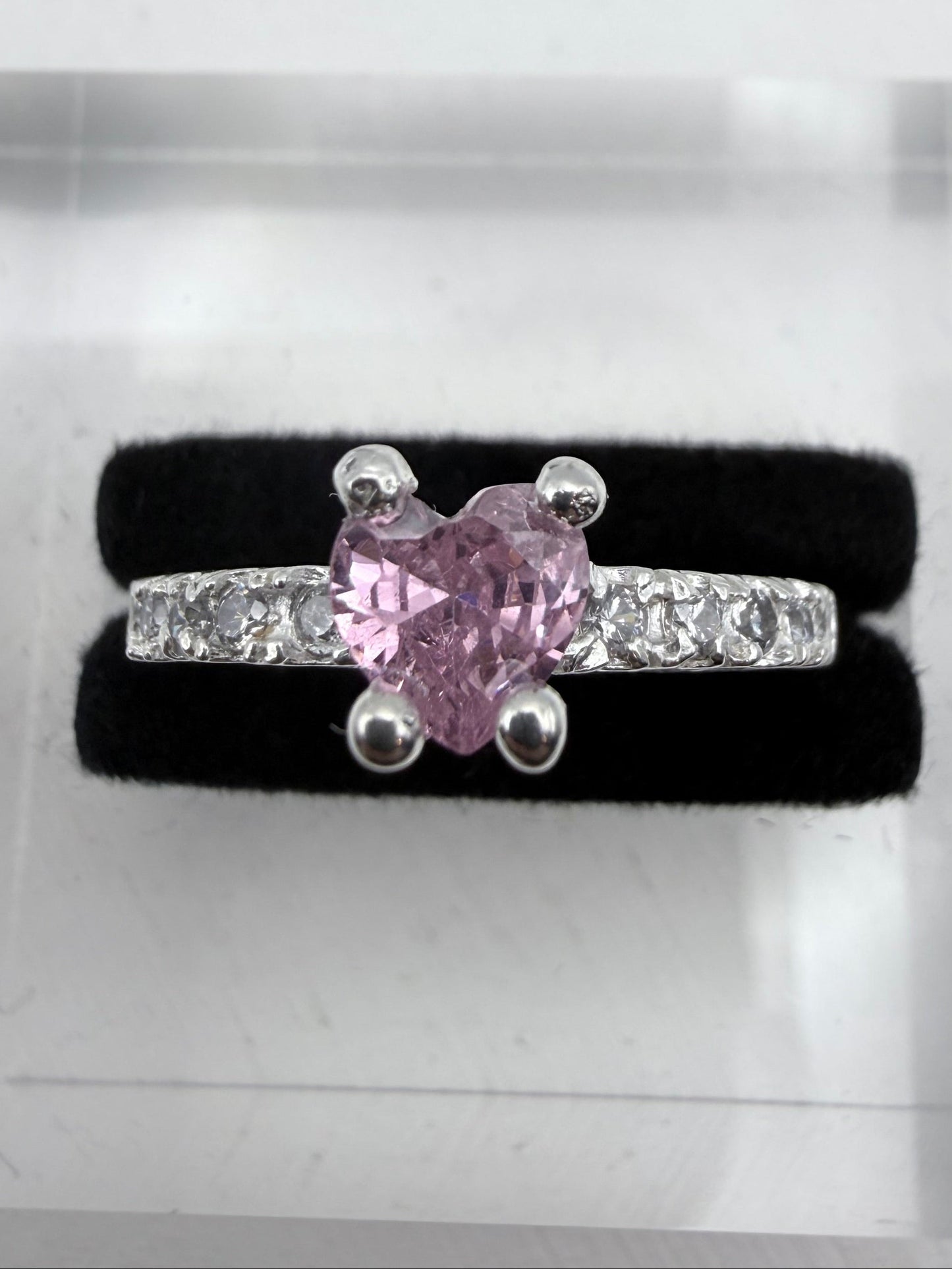 Pink diamond ring with diamonds on a black cushion in a jewelry box
