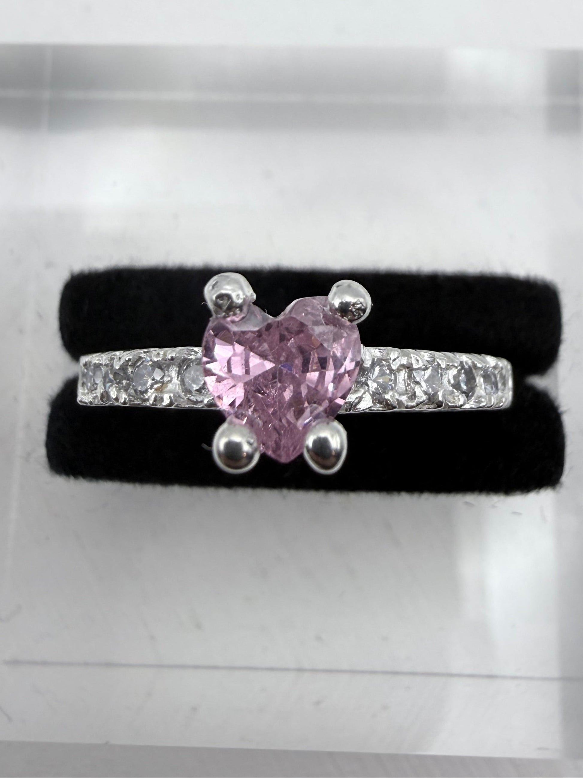 Pink diamond ring with diamonds on a black cushion in a jewelry box