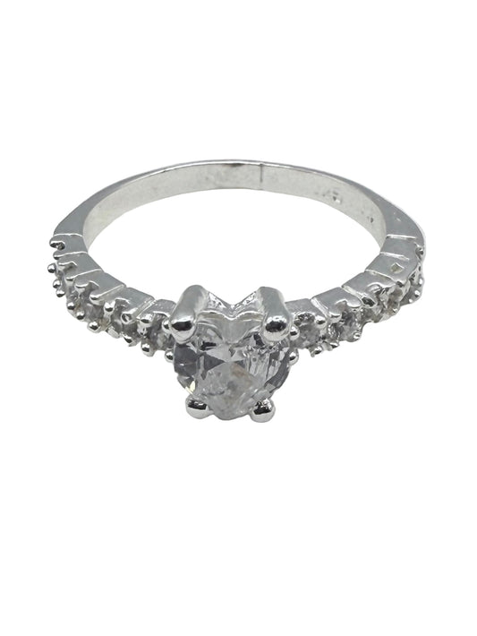 Silver ring with a diamond on a white surface