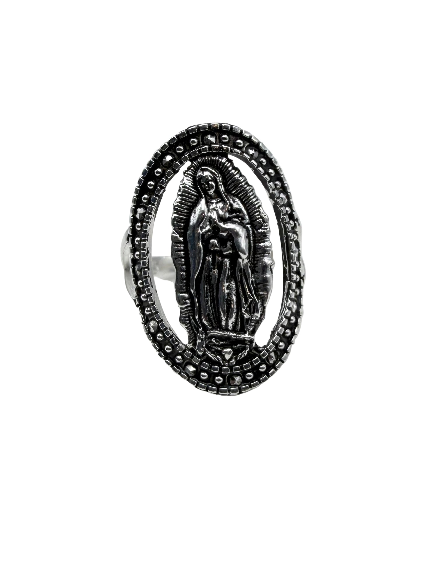 Silver ring with religious design on a white cushion