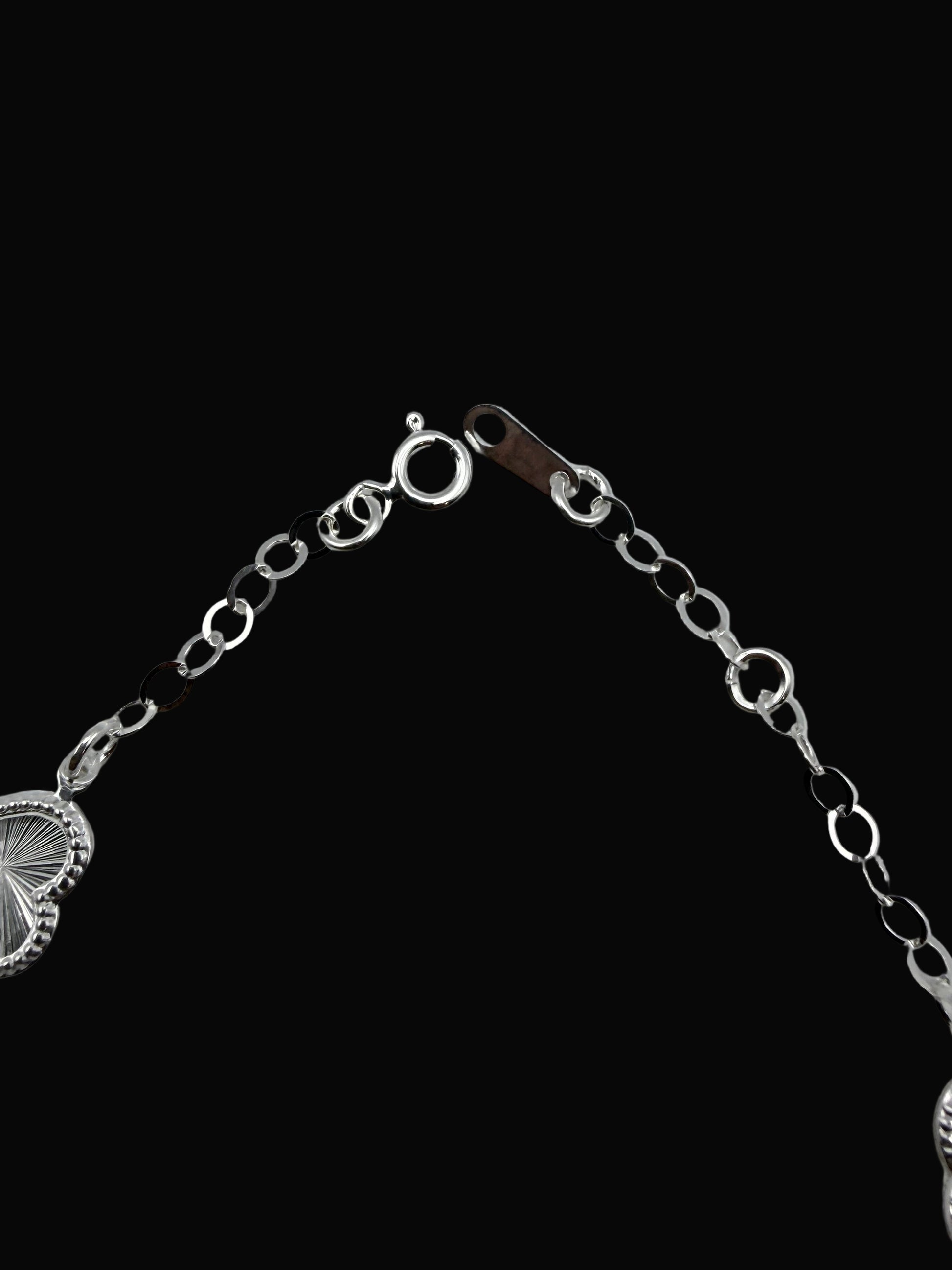 Silver bracelet with heart-shaped ends on a gray background