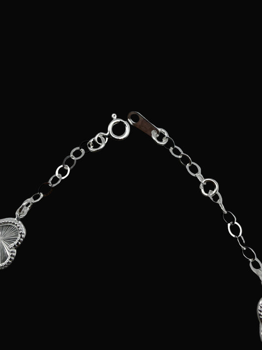Silver bracelet with heart-shaped ends on a gray background