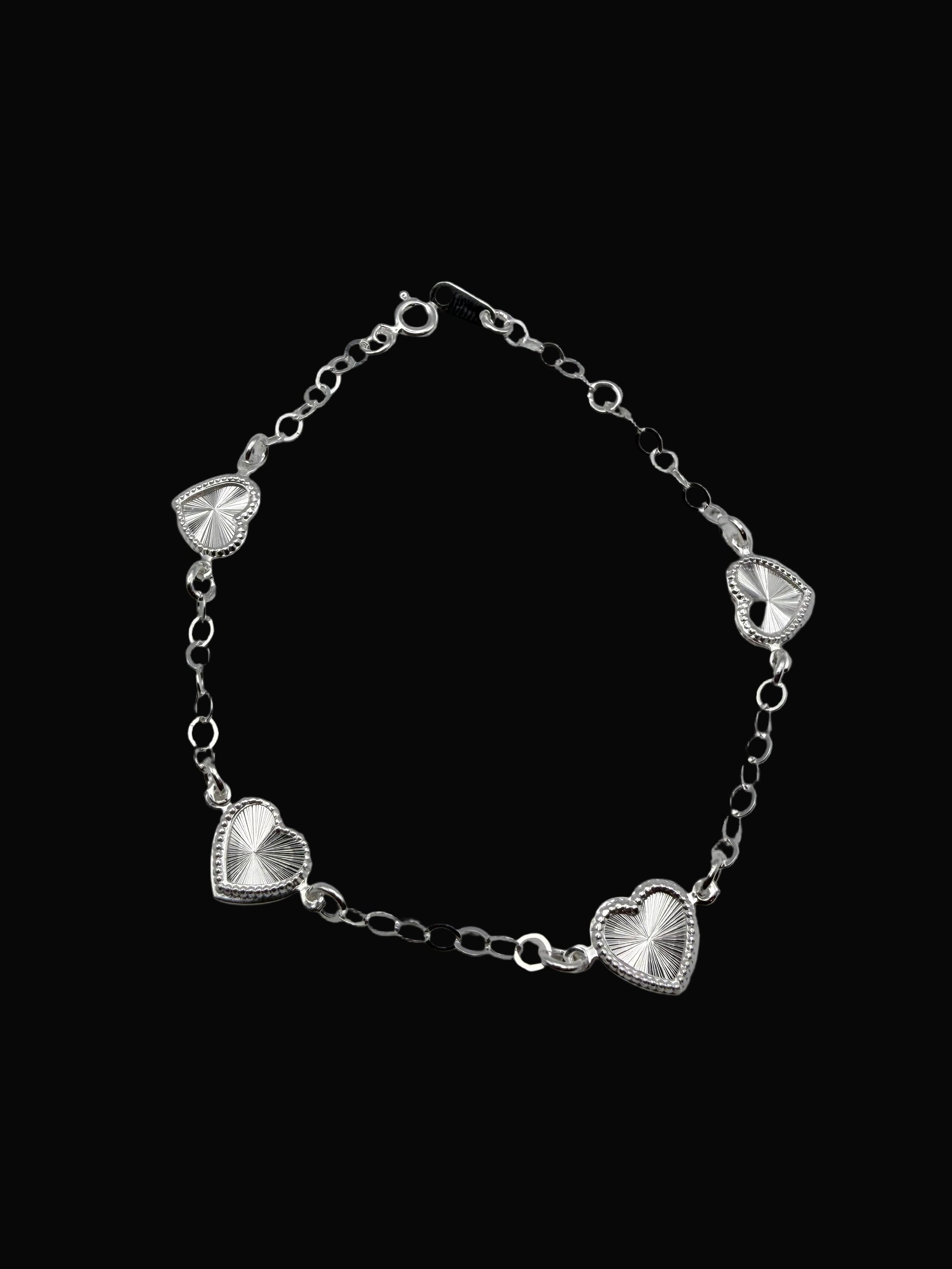 Silver bracelet with heart-shaped charms on a gray background