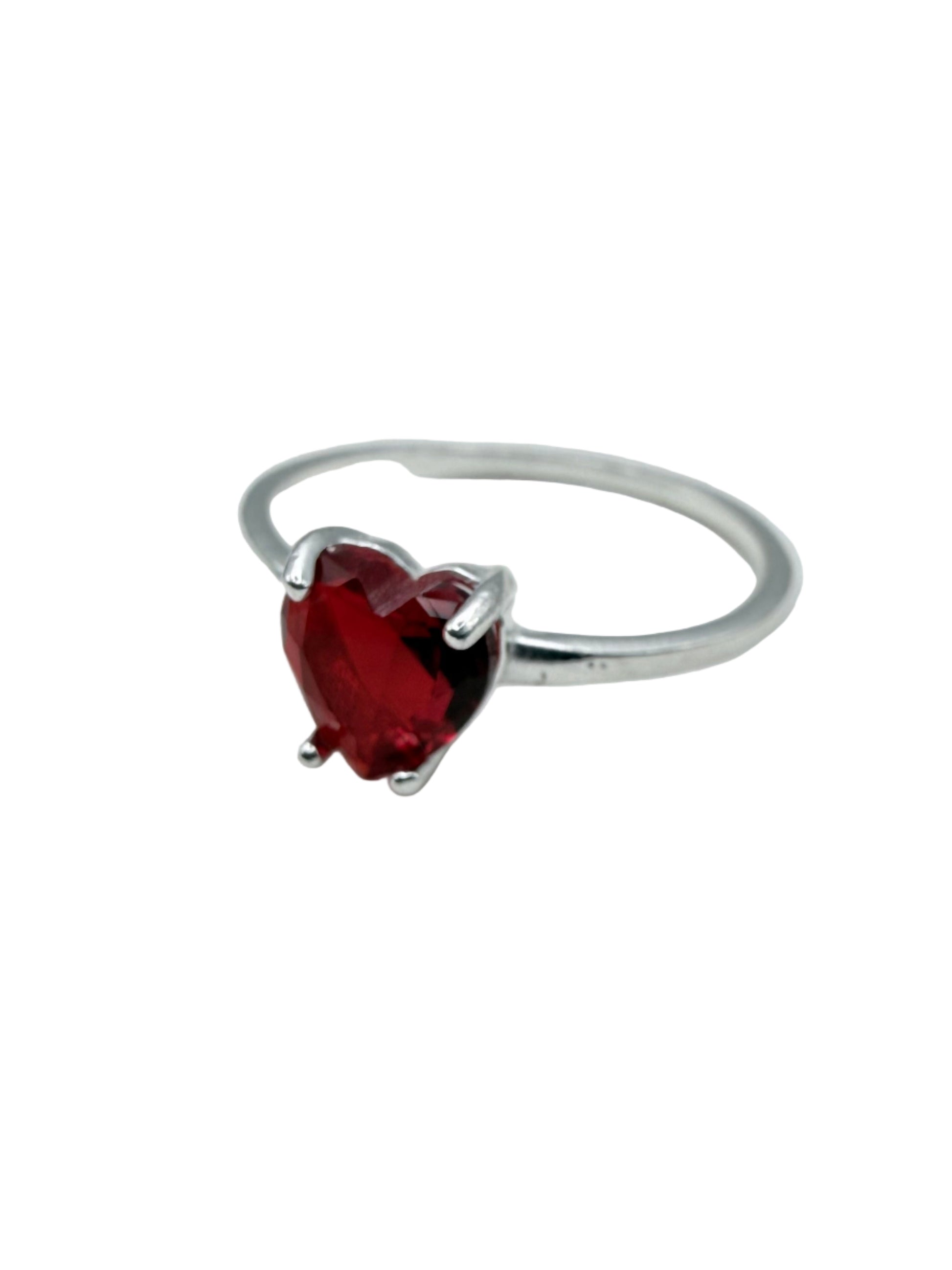 Silver ring with a red gemstone on a white background
