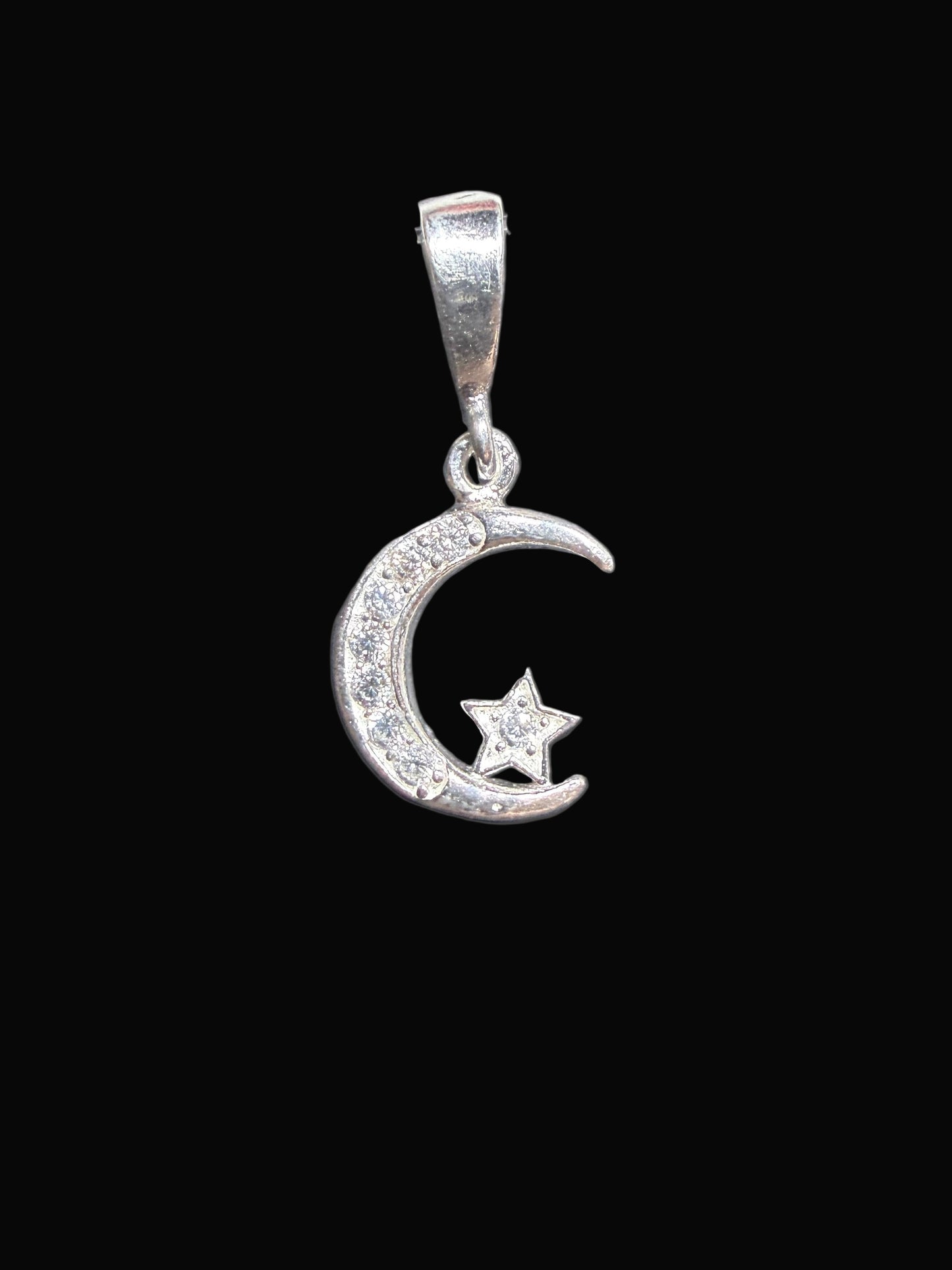 Silver ring with a moon and star design on a dark surface