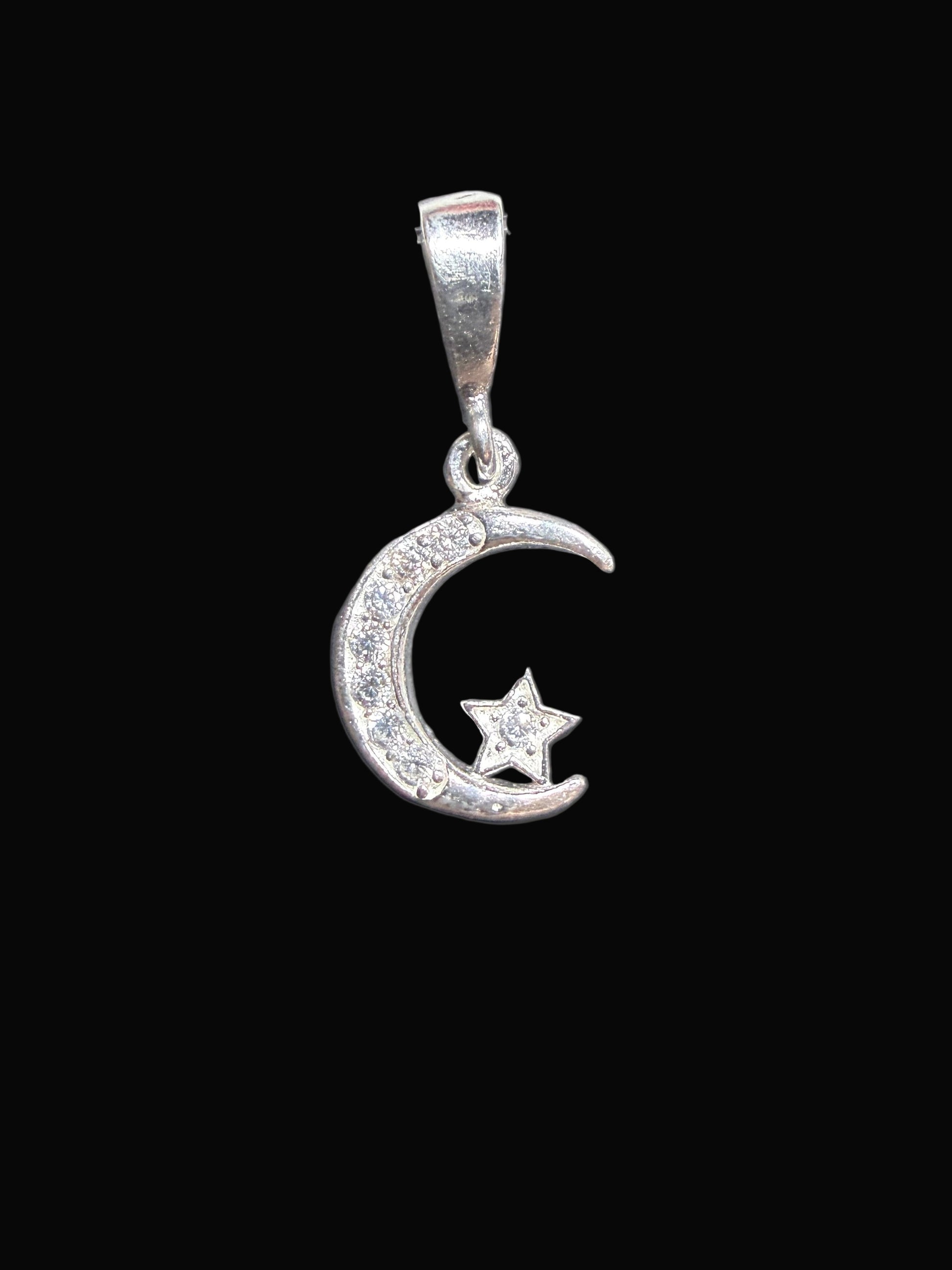 Silver ring with a moon and star design on a dark surface