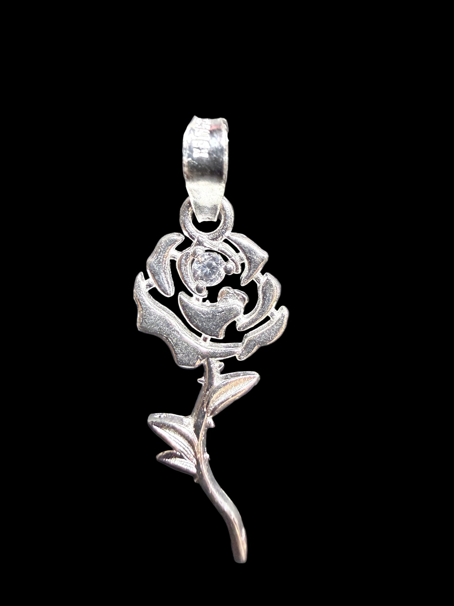 Silver rose-shaped pendant on a gray background