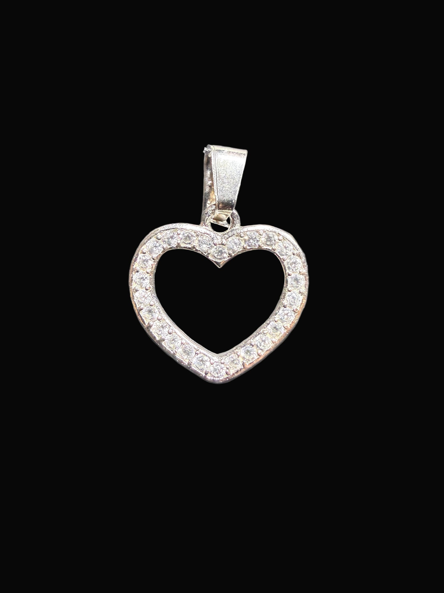 Heart-shaped silver pendant on a clear card against a gray background