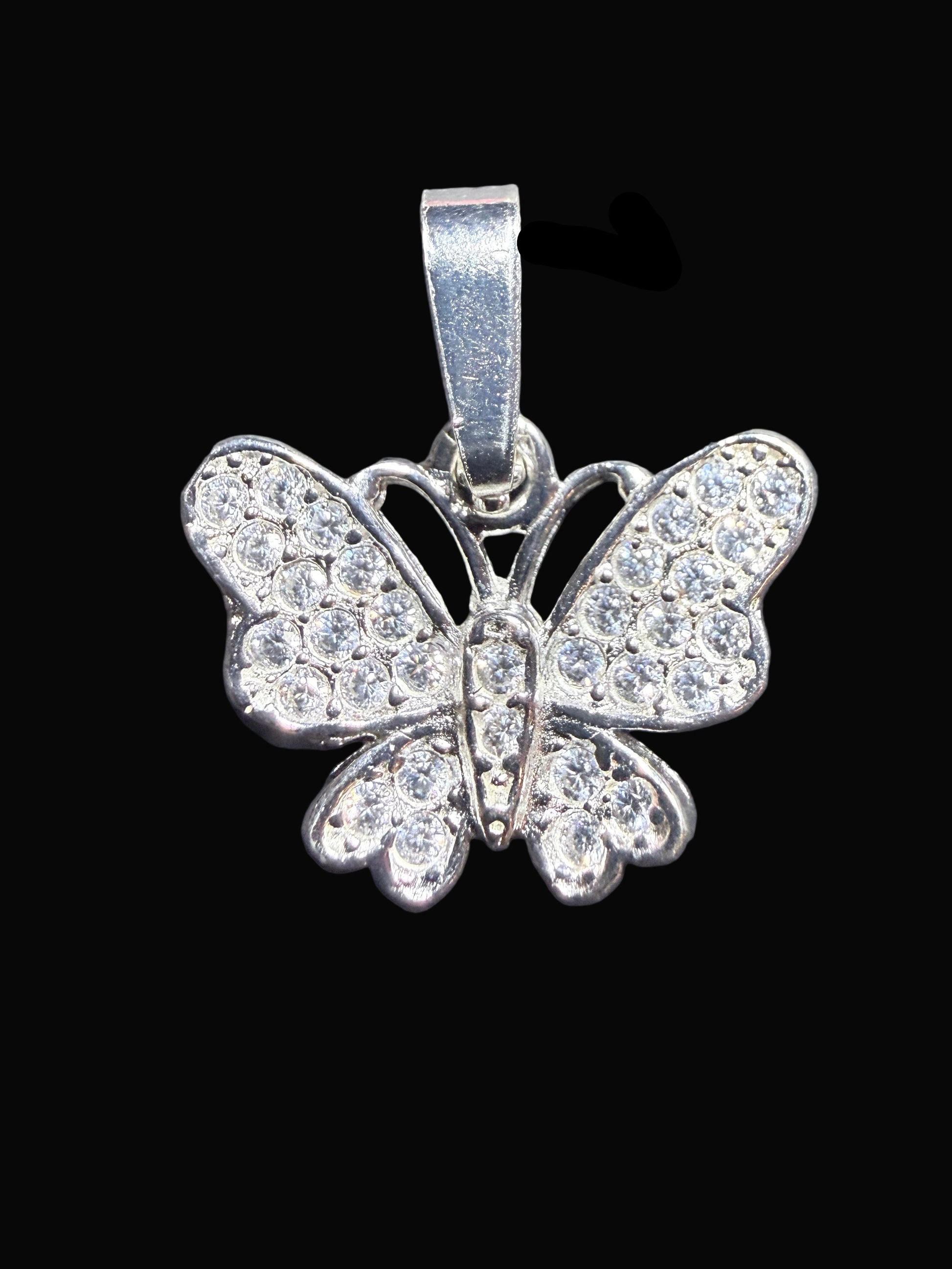 Butterfly-shaped pendant with rhinestones on a dark textured surface