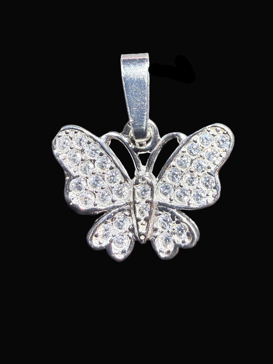 Butterfly-shaped pendant with rhinestones on a dark textured surface