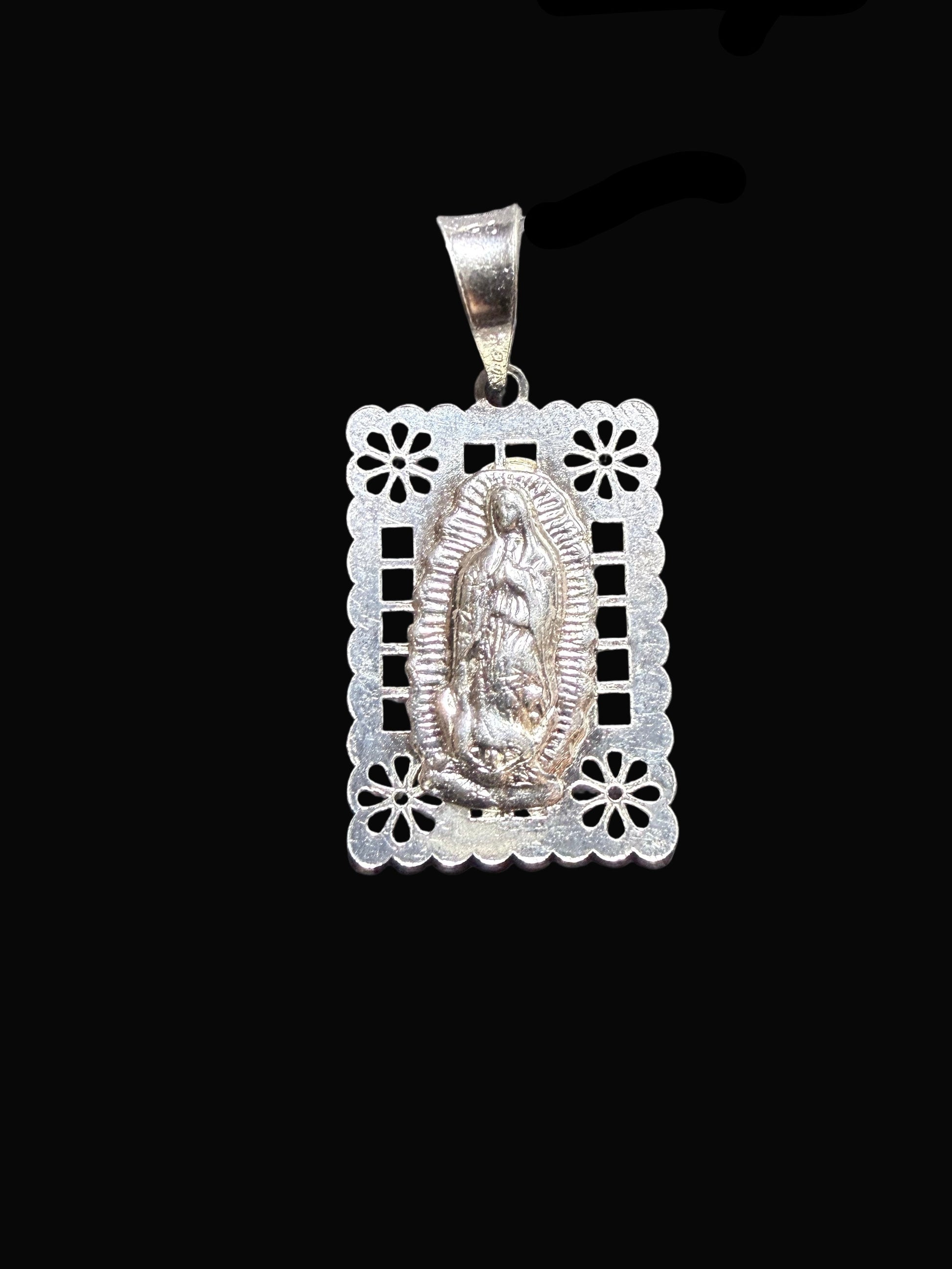 Silver pendant with intricate design on a black background