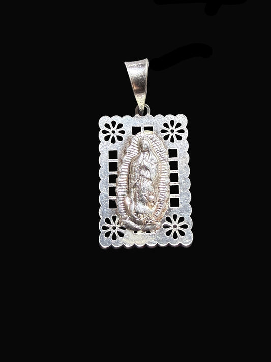 Silver pendant with intricate design on a black background