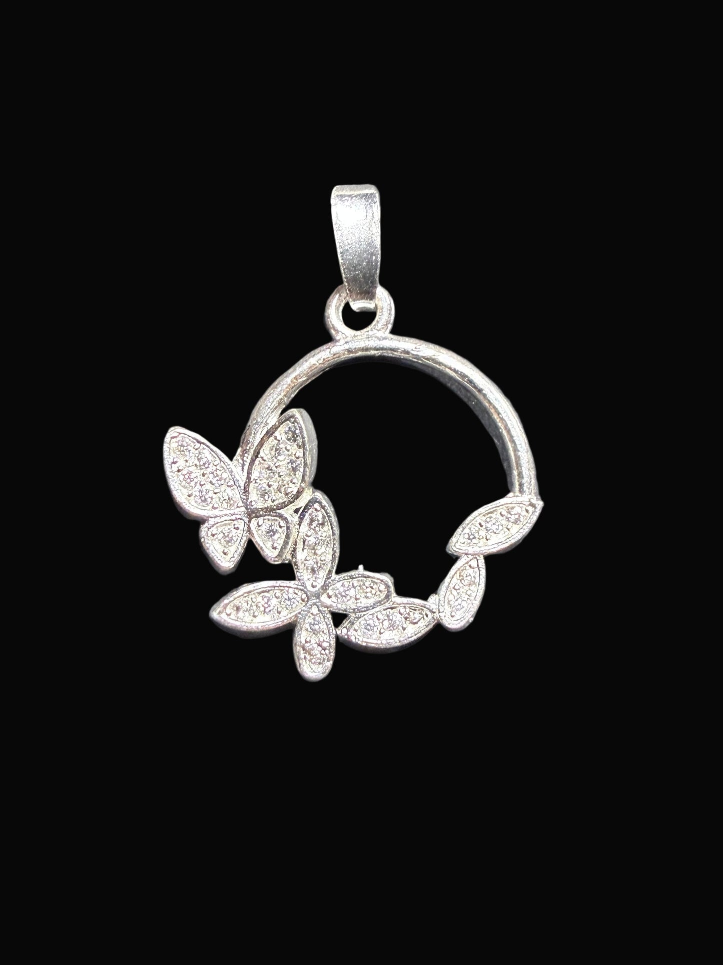 Silver pendant with butterfly design on a black background