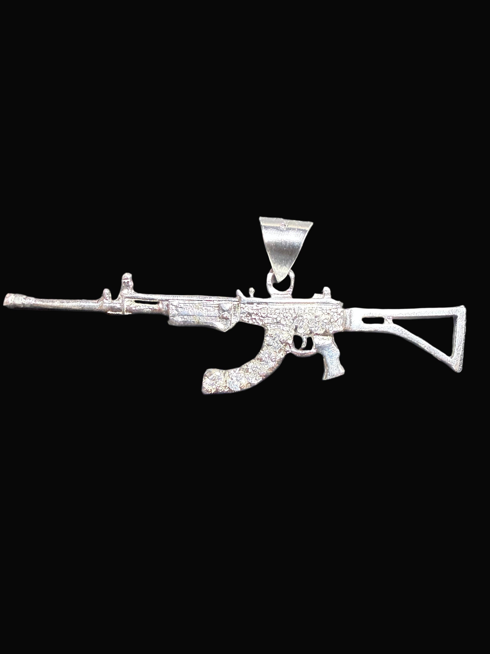 Silver gun-shaped pendant on a dark gray background