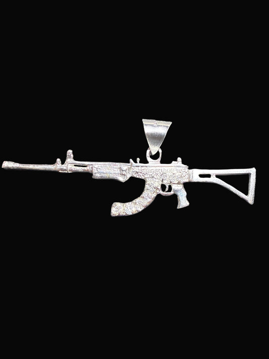 Silver gun-shaped pendant on a dark gray background