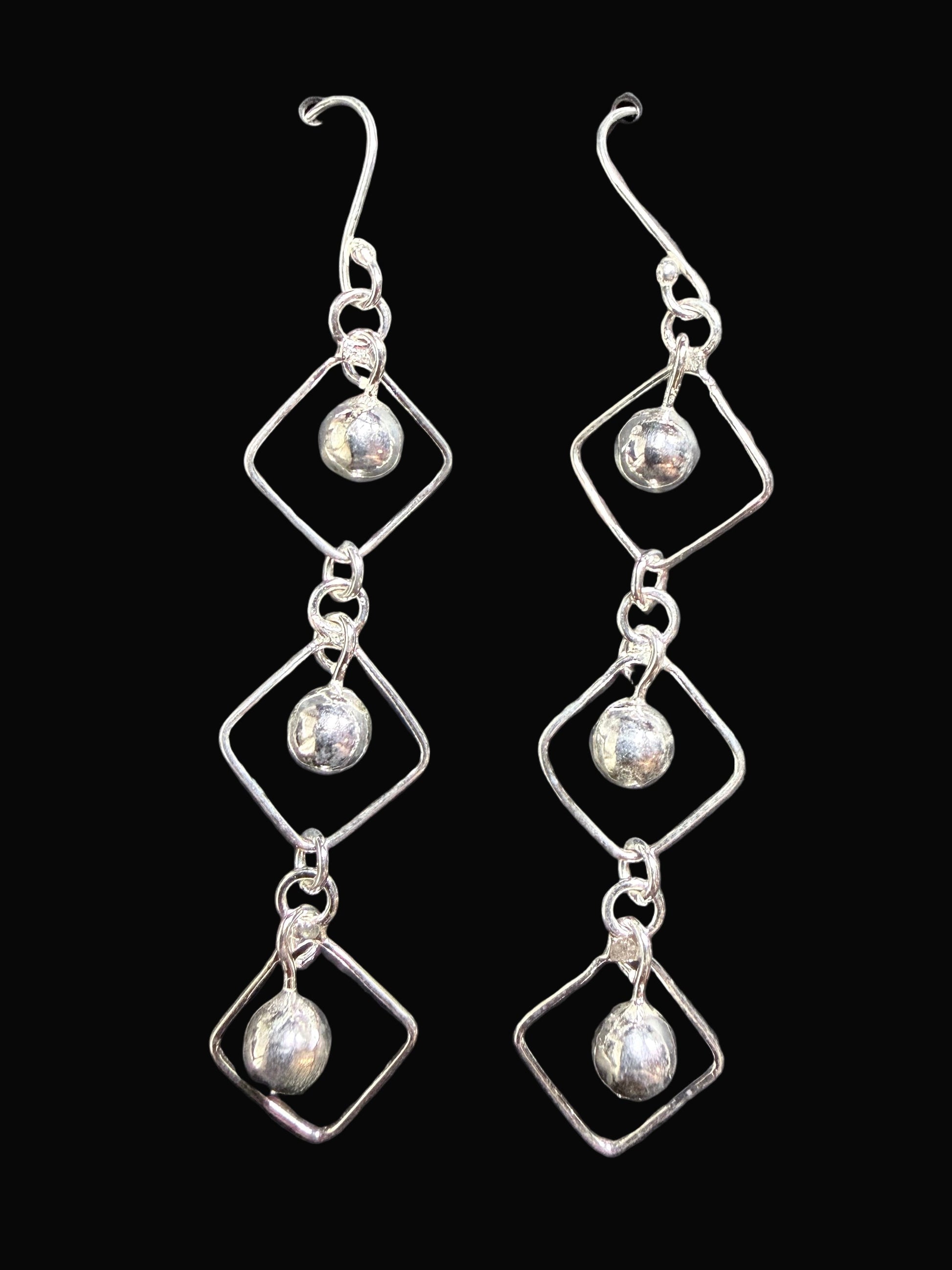 Pair of silver earrings on a gray card