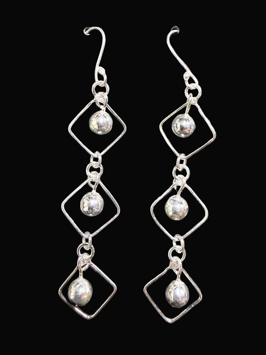 Pair of silver earrings on a gray card
