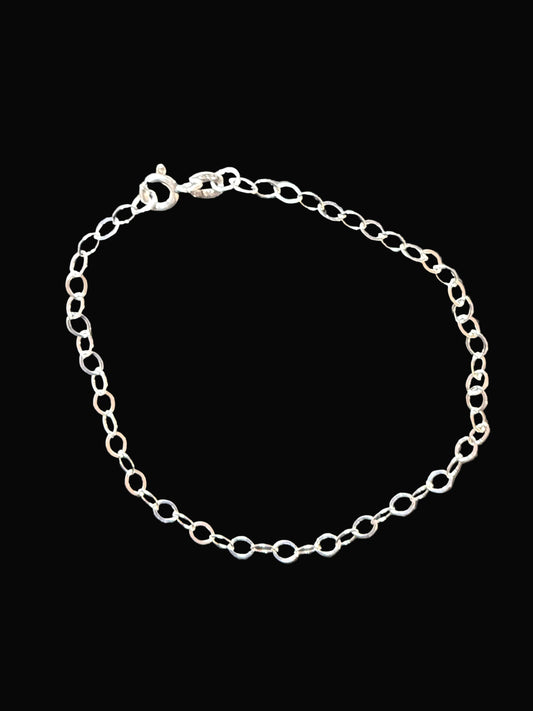 Silver chain bracelet on a dark gray surface