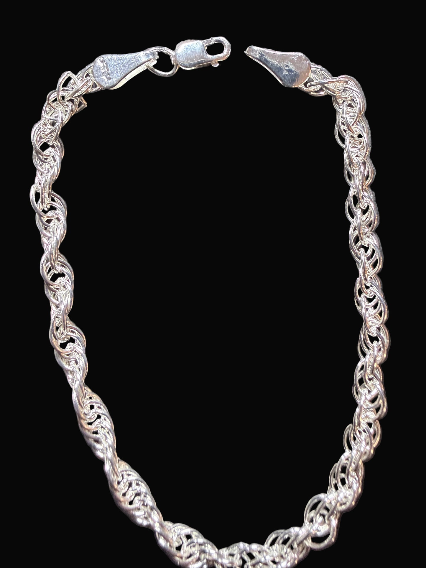 Silver chain bracelet on a dark gray surface