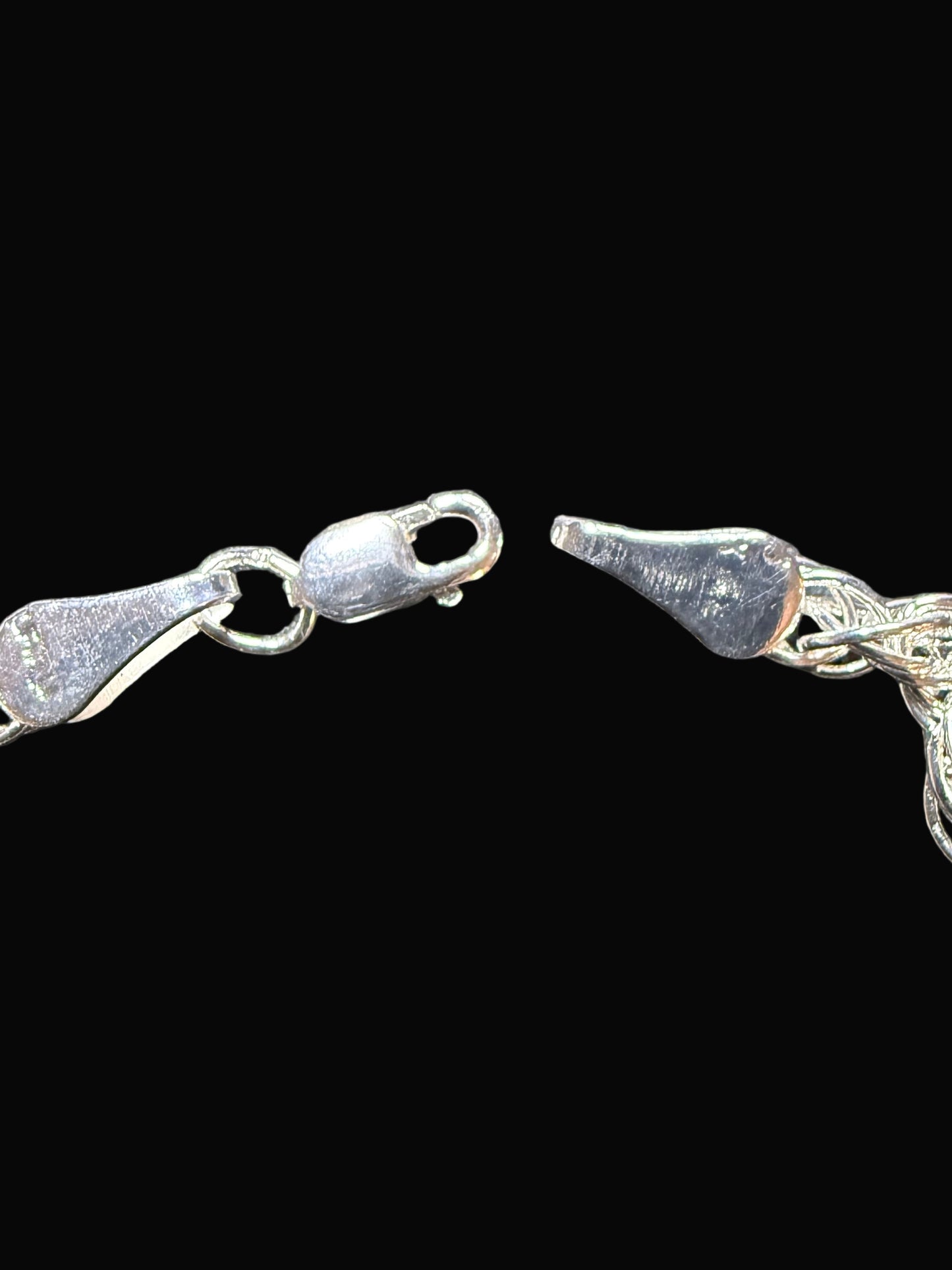 Silver chain bracelet on a textured dark surface