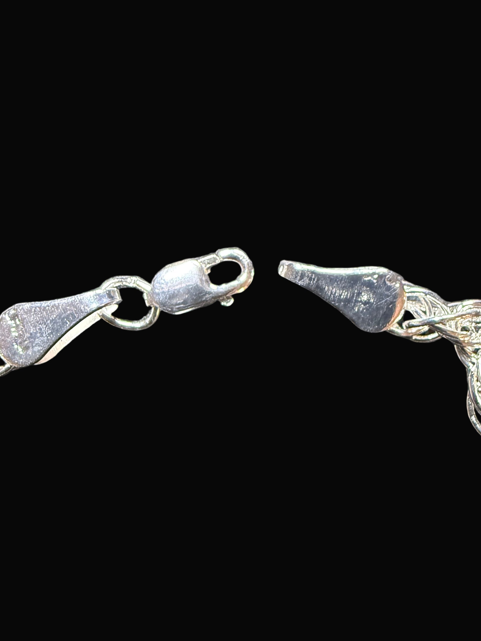 Silver chain bracelet on a textured dark surface