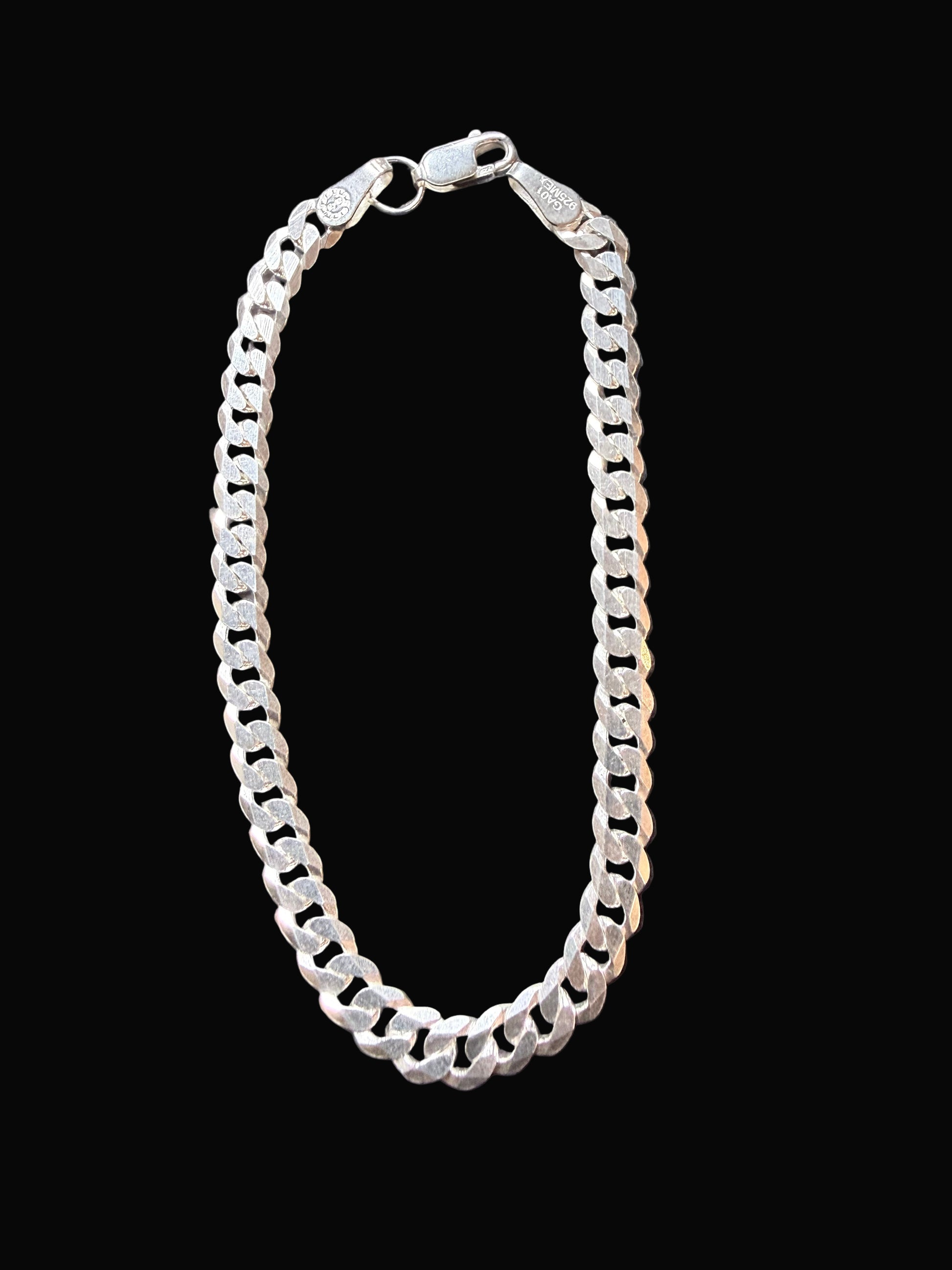 Silver chain bracelet on a dark gray surface