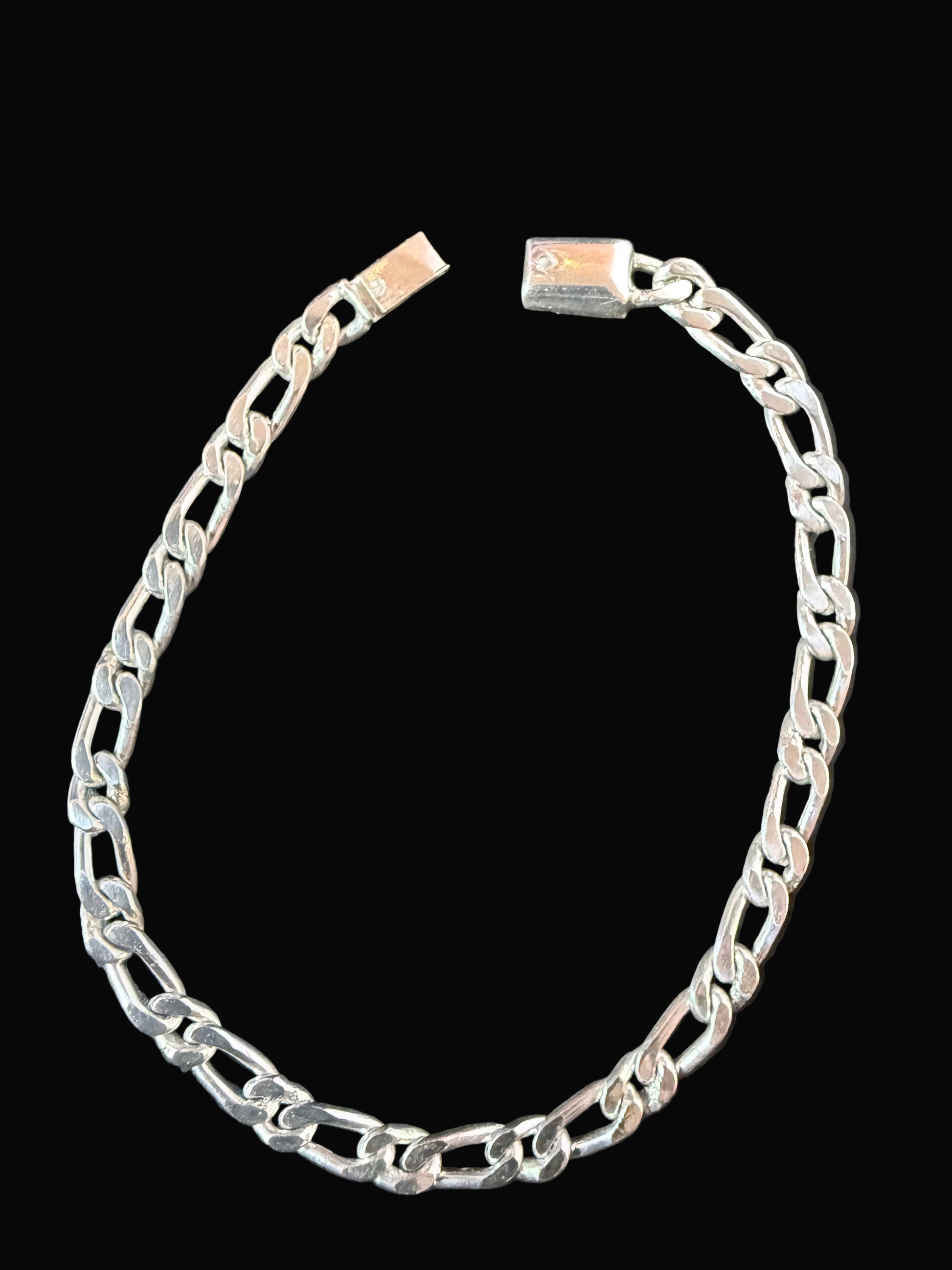 Silver chain bracelet on a dark surface