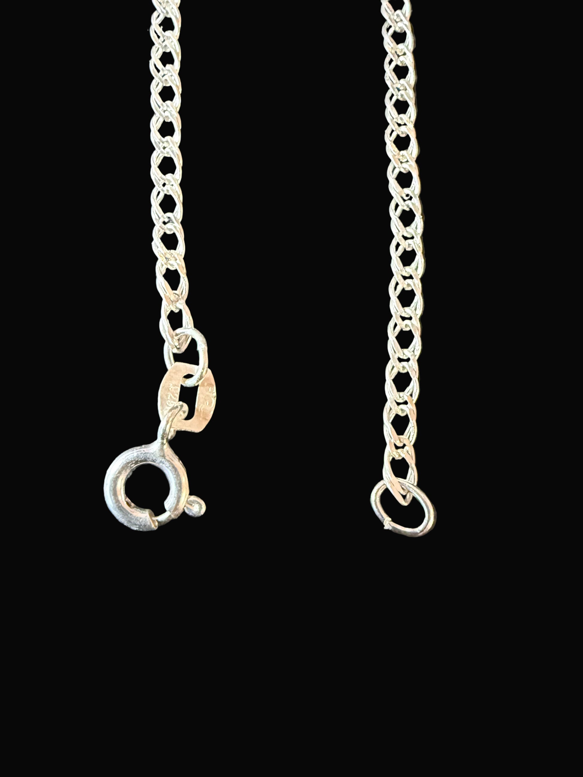 Silver chain necklace on a dark surface
