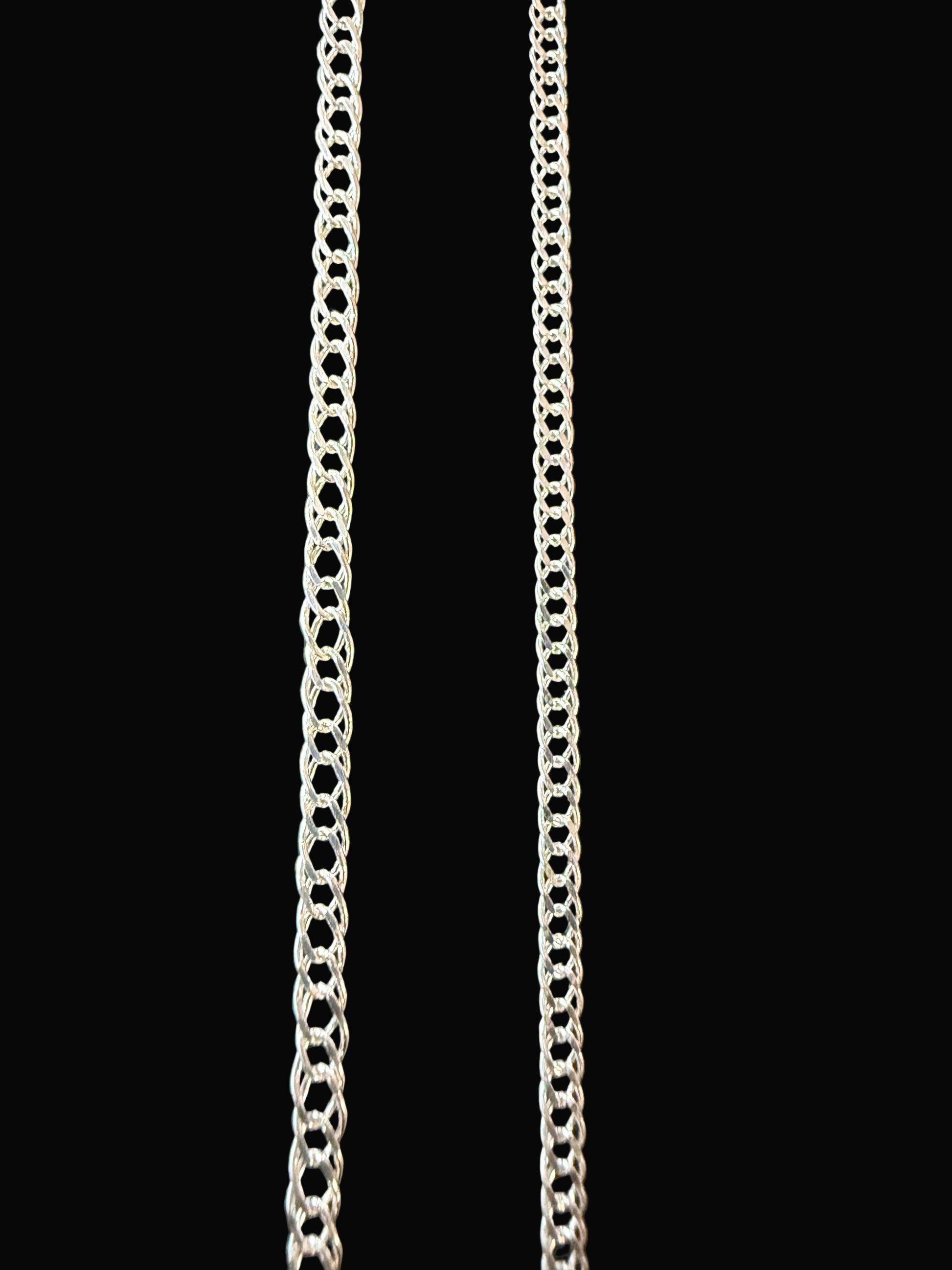 Two silver chains on a black textured surface