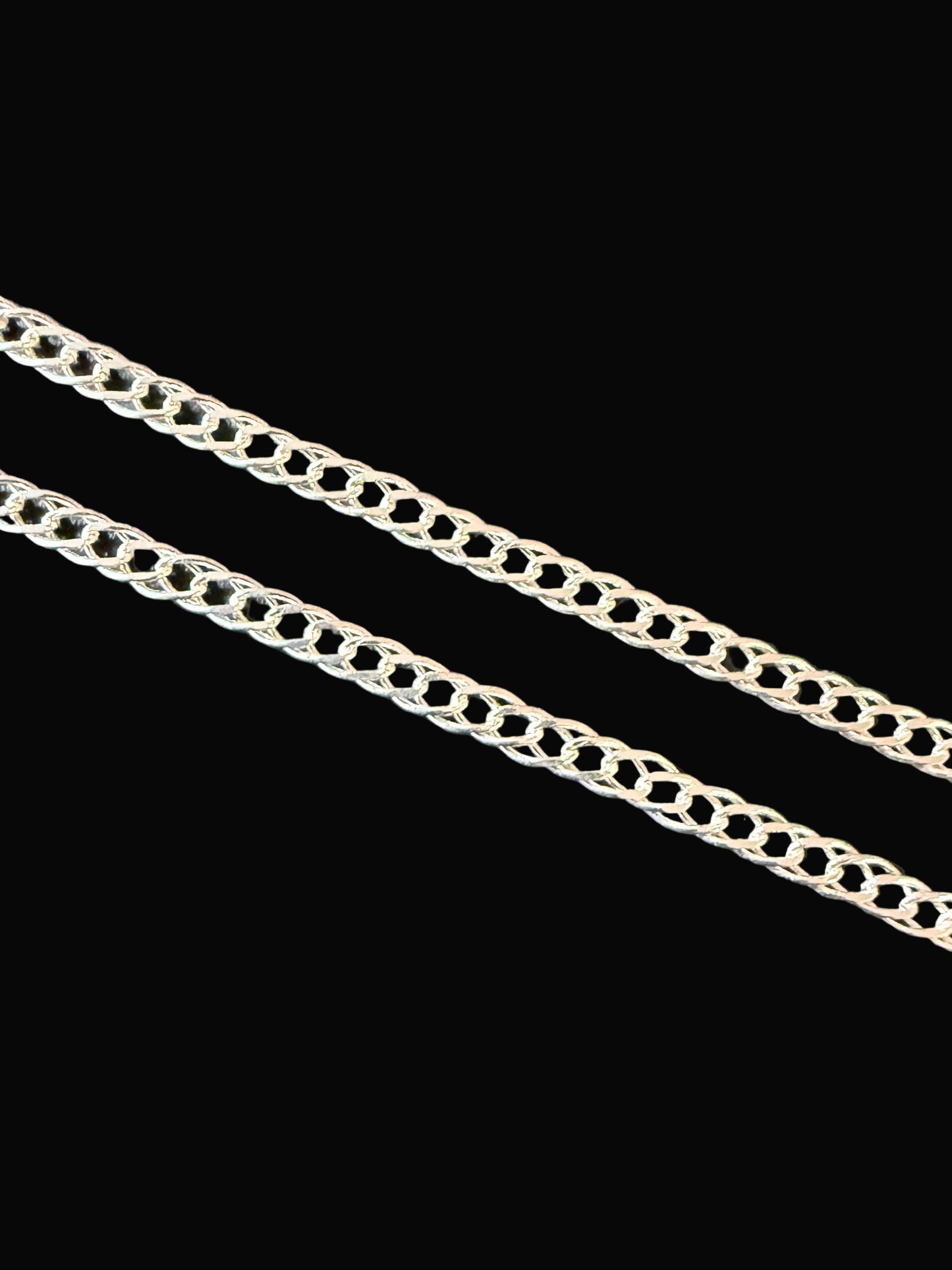 Silver chain on a dark textured surface
