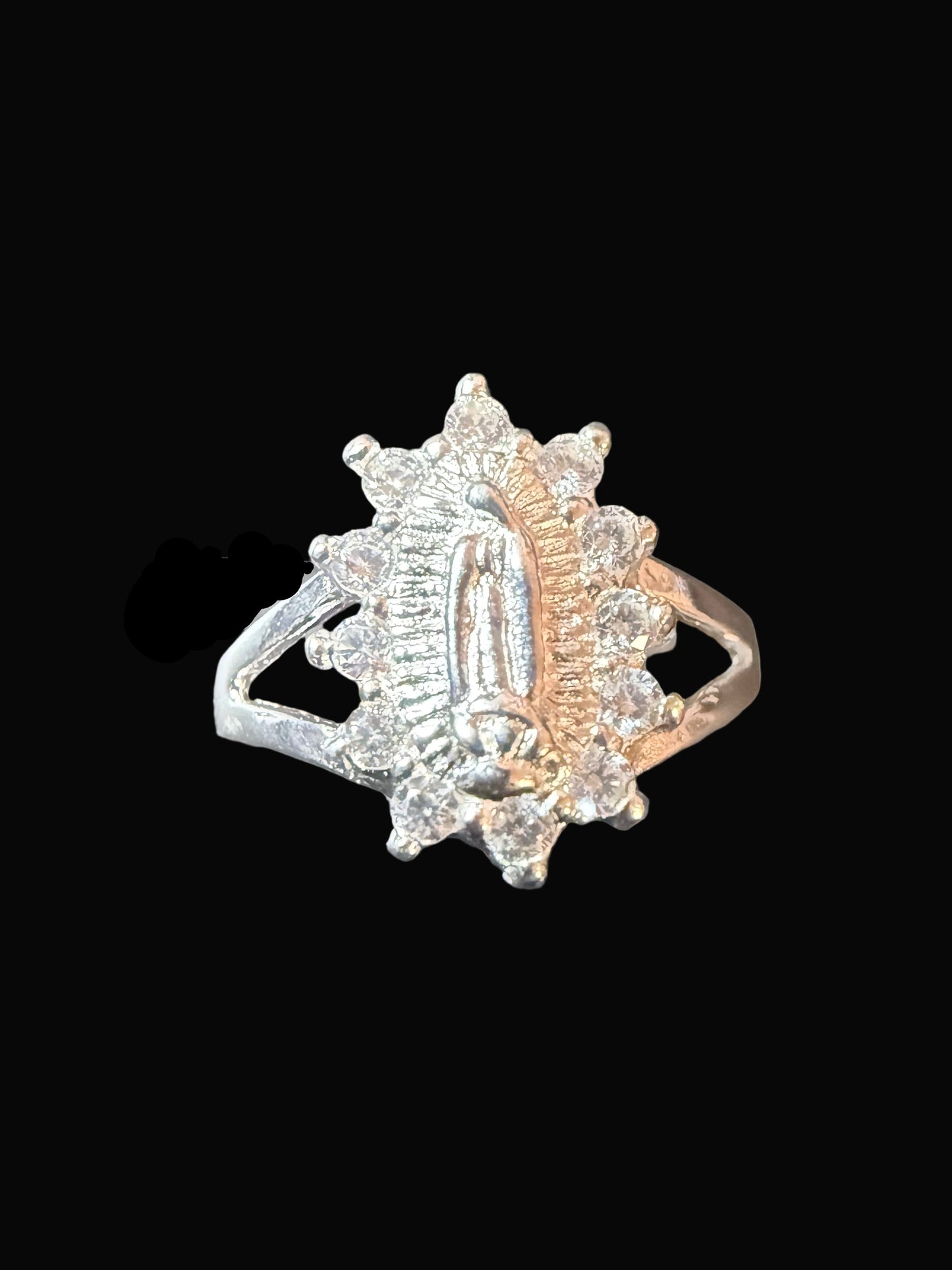 Silver ring with gemstones on a clear stand against a dark background