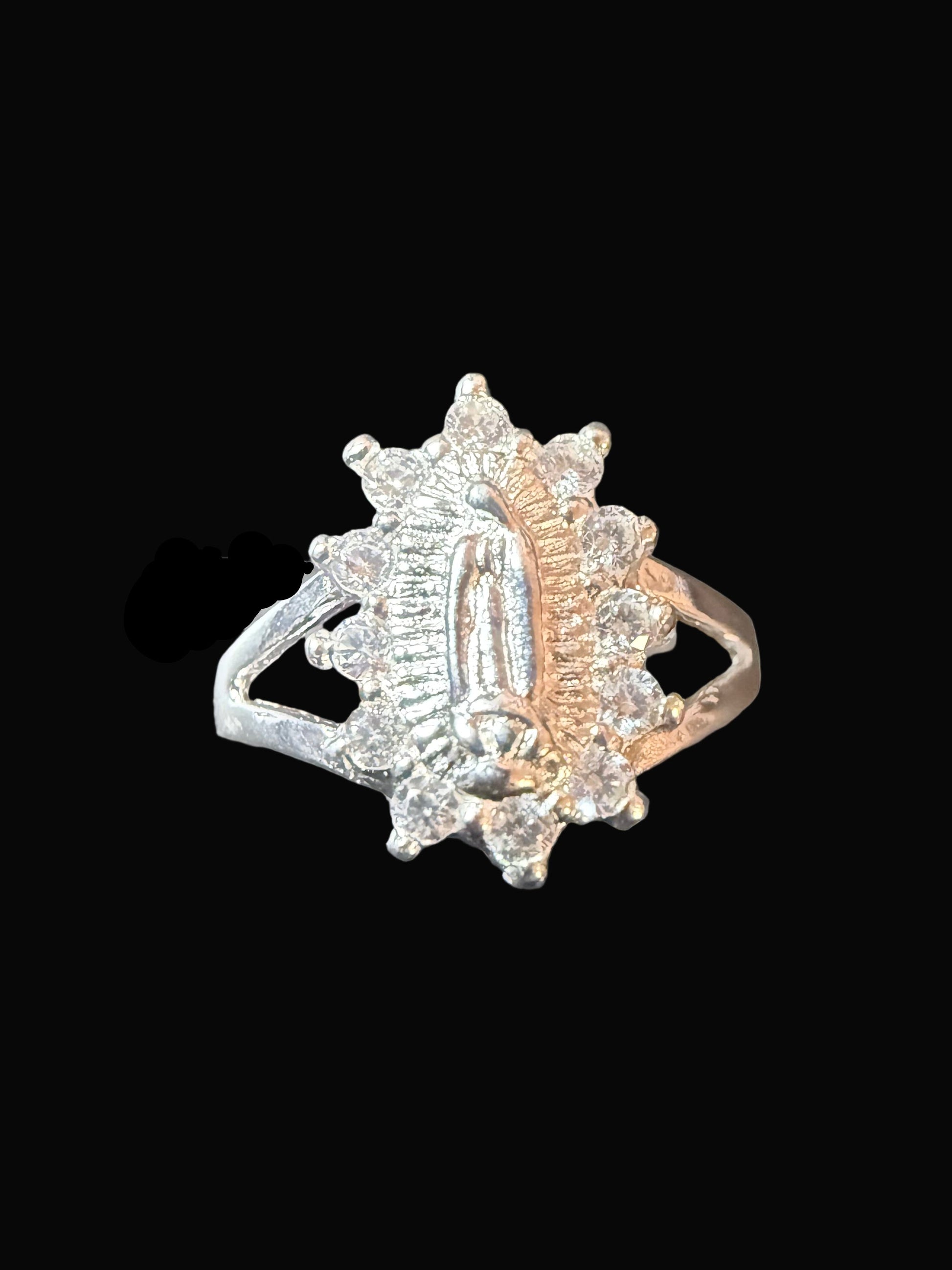 Silver ring with gemstones on a clear stand against a dark background